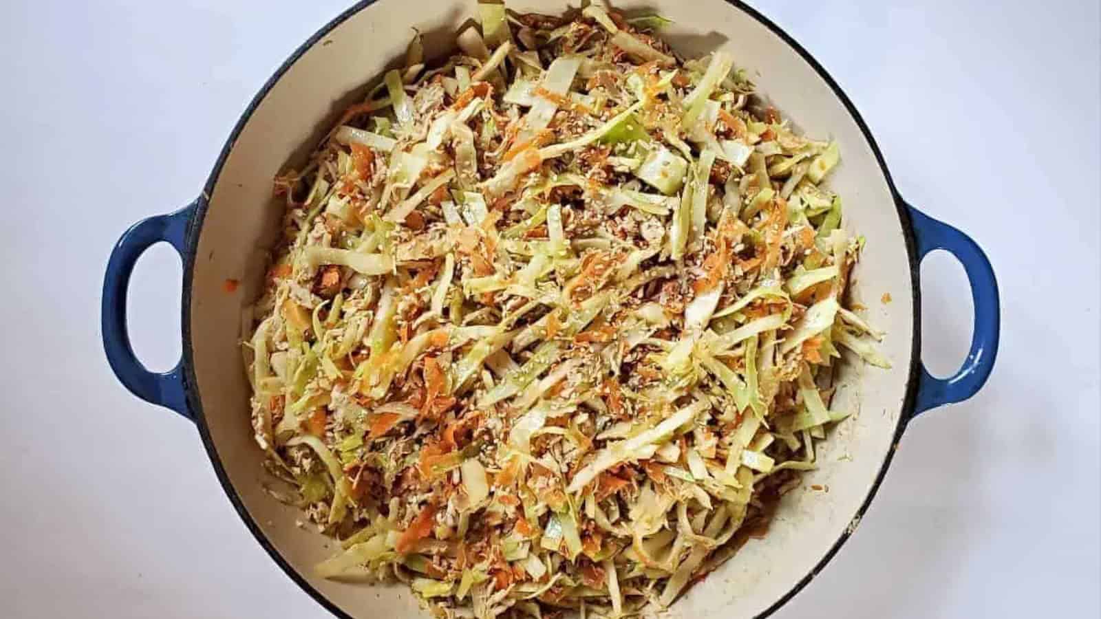 Image shows a closeup of chicken egg roll in a bowl in a blue enameled cast iron pot.