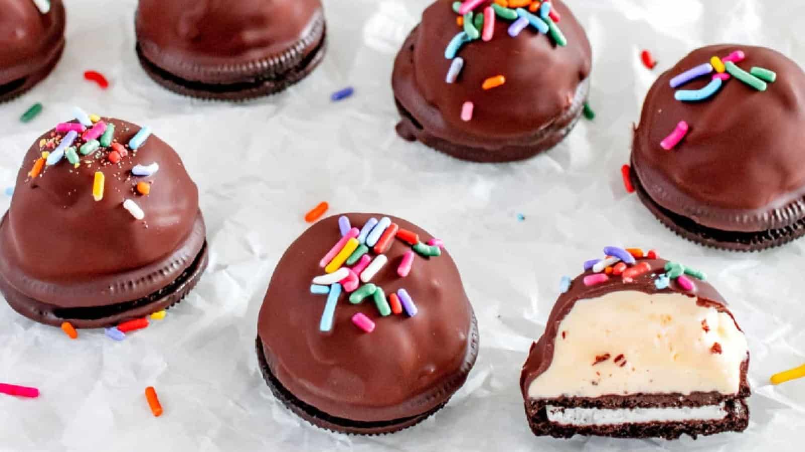 Chocolate covered ice cream bites on a piece of parchment paper.