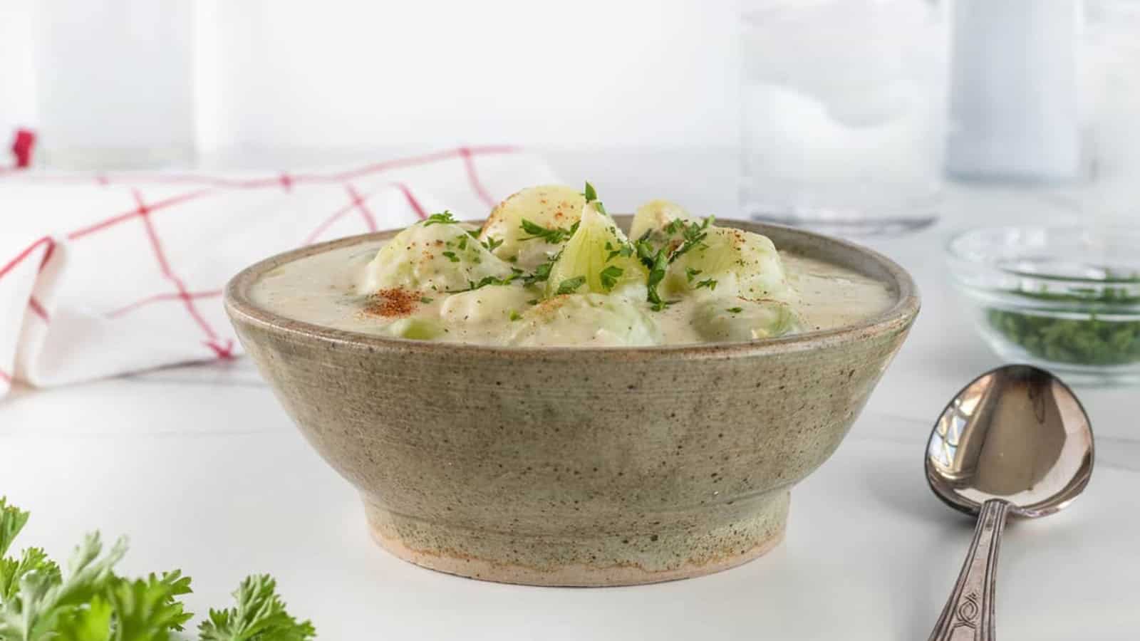 Creamed onions in a creamy sauce topped with parsley and seasoning in a bowl.