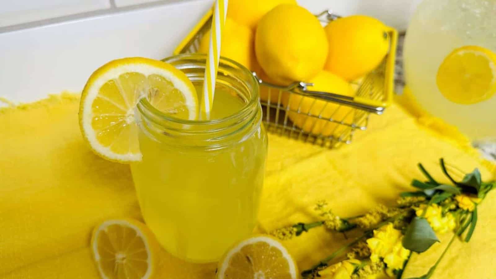 Fresh squeezed lemonade with straw in mason jar.