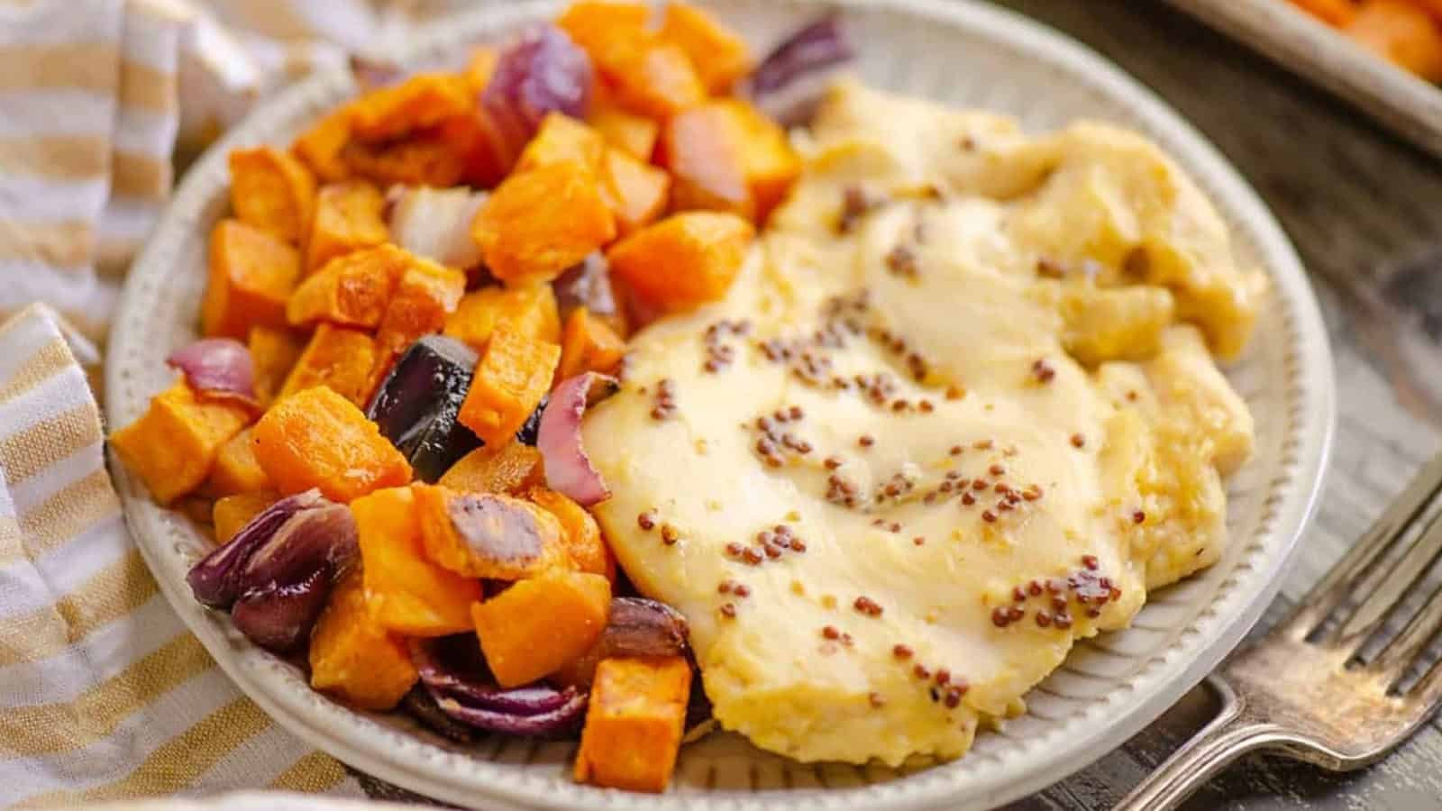 A plate with roasted sweet potatoes, red onions, and mashed potatoes topped with whole grain mustard.