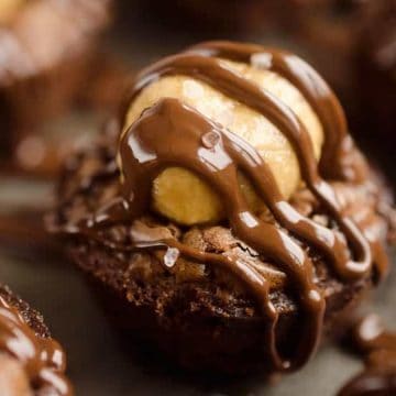 Close-up of a chocolate brownie topped with peanut butter and drizzled with melted chocolate.