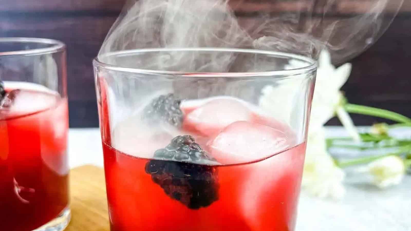 Smoked Blackberry Margarita with smoke coming out the top of the glass.